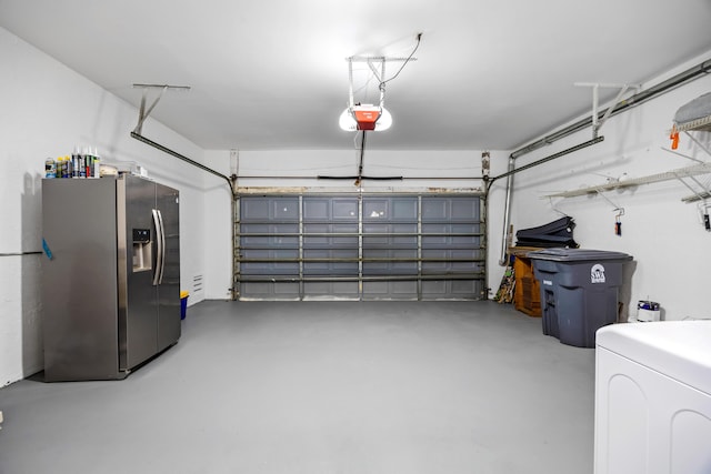 garage featuring stainless steel fridge, washer / dryer, and a garage door opener