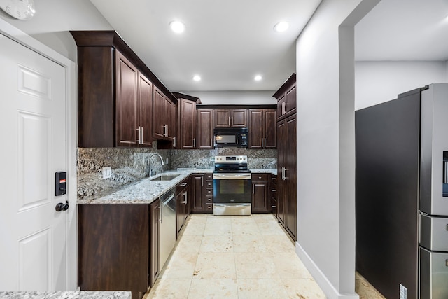 kitchen featuring light stone countertops, sink, tasteful backsplash, dark brown cabinets, and appliances with stainless steel finishes