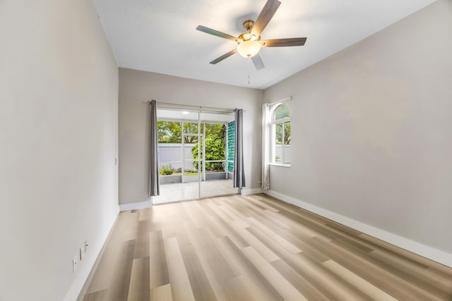 empty room featuring a textured ceiling, light hardwood / wood-style floors, and ceiling fan