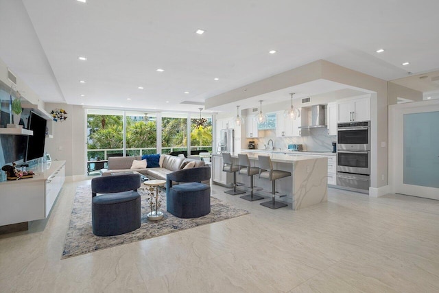 living room featuring expansive windows and sink