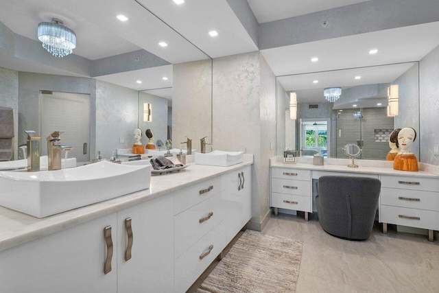 bathroom with a chandelier, vanity, and a shower with door