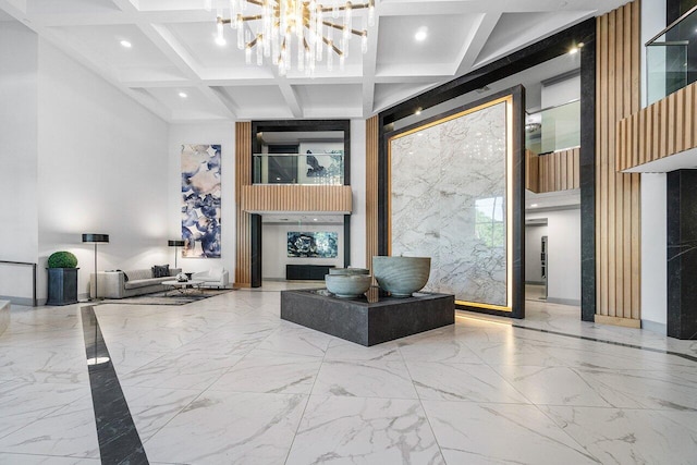 interior space featuring beam ceiling, a towering ceiling, coffered ceiling, and an inviting chandelier