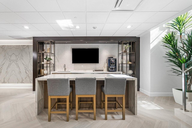 bar with a paneled ceiling and sink