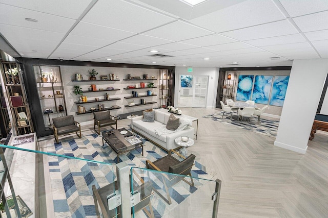 living room featuring a paneled ceiling and light parquet floors