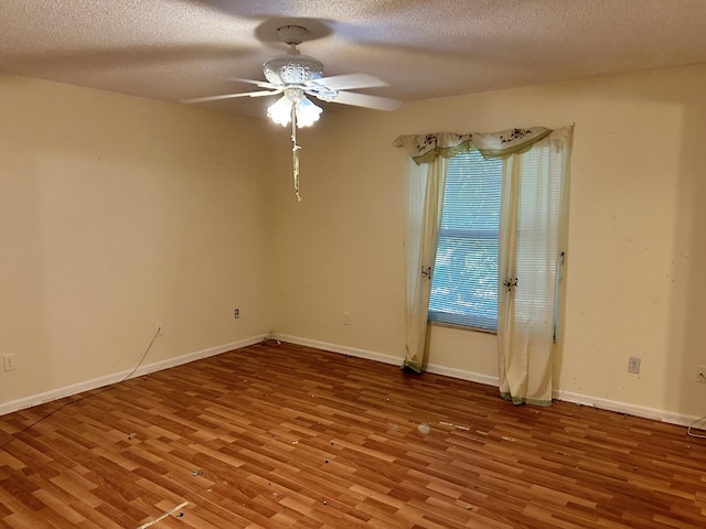 empty room with hardwood / wood-style floors, ceiling fan, and a textured ceiling