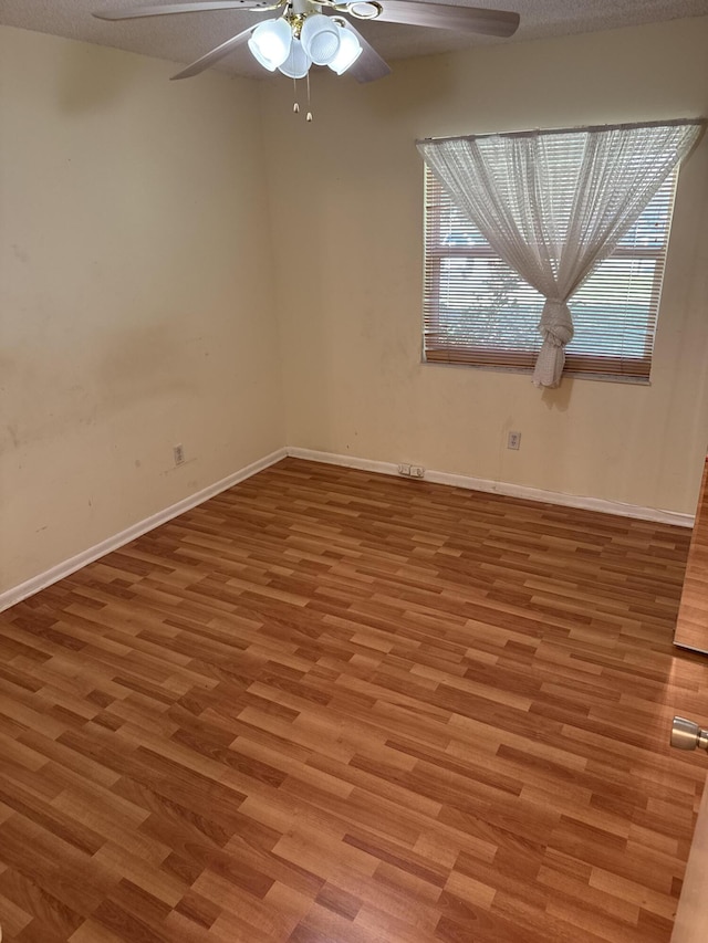 empty room with ceiling fan, hardwood / wood-style floors, and a textured ceiling