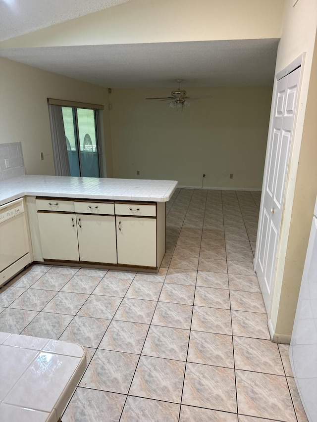 kitchen featuring kitchen peninsula, light tile patterned floors, ceiling fan, and lofted ceiling