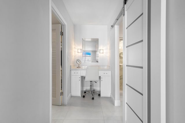 corridor featuring light tile patterned flooring and a barn door