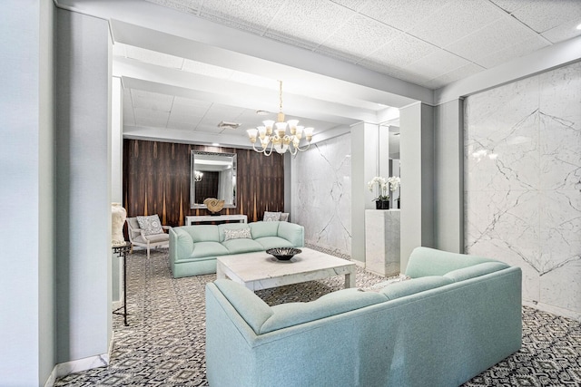 living room with wood walls, a notable chandelier, and dark carpet