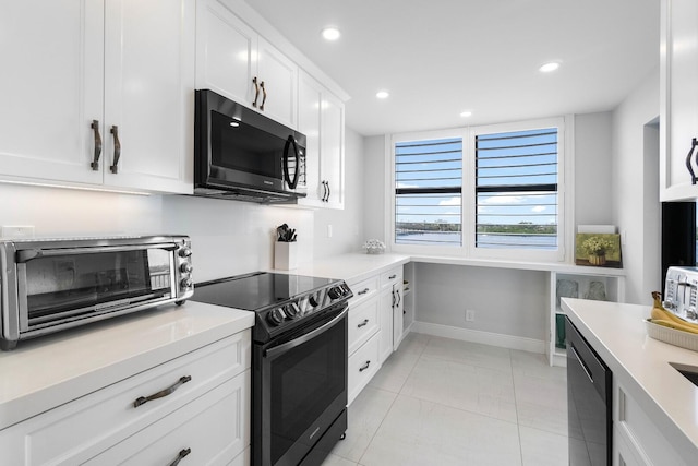 kitchen with electric range, white cabinets, stainless steel dishwasher, and light tile patterned floors