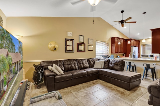 living room featuring ceiling fan, a healthy amount of sunlight, light tile patterned floors, and vaulted ceiling