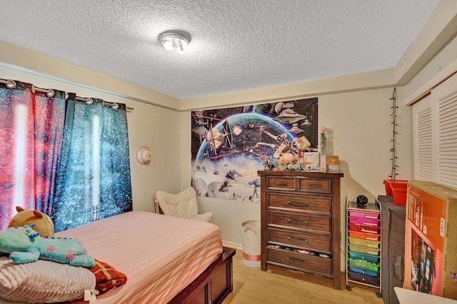 bedroom featuring a textured ceiling and light wood-type flooring