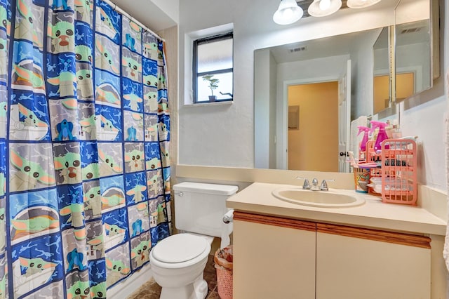 bathroom with curtained shower, vanity, and toilet