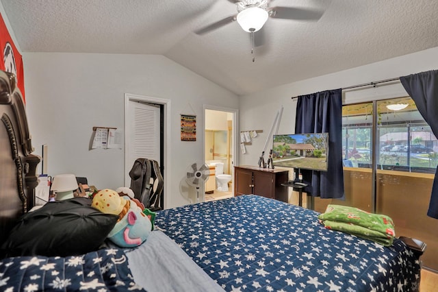 bedroom with a textured ceiling, vaulted ceiling, ensuite bath, and ceiling fan