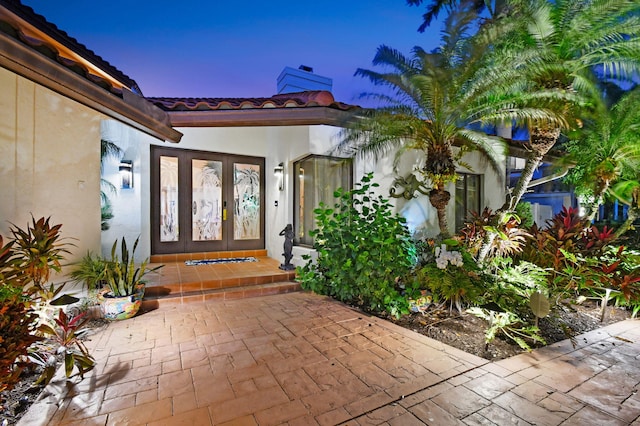 exterior entry at dusk featuring french doors