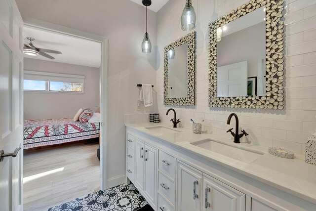 bathroom with ceiling fan, tile patterned floors, vanity, and backsplash