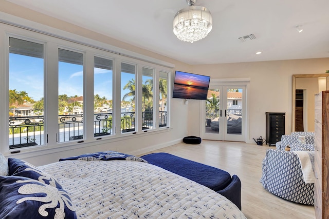 bedroom with access to exterior, an inviting chandelier, and french doors