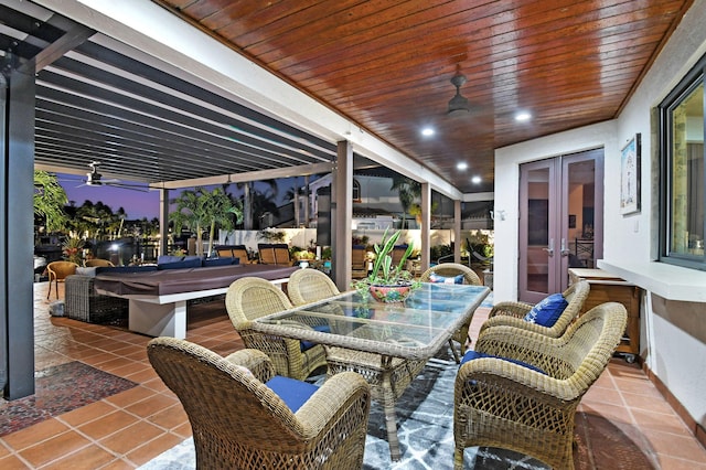 patio terrace at dusk featuring an outdoor living space, ceiling fan, and french doors