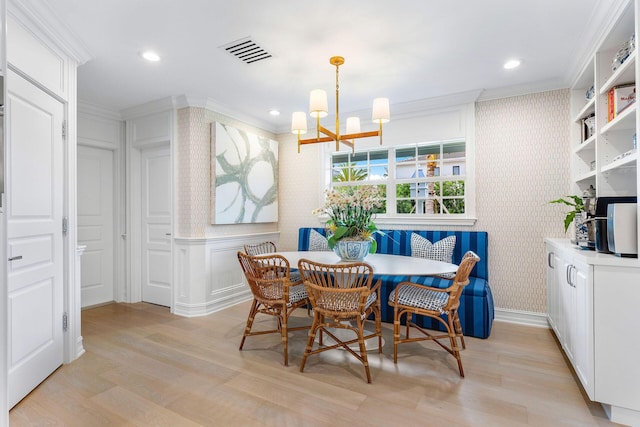 dining room with crown molding, breakfast area, light hardwood / wood-style floors, and a notable chandelier