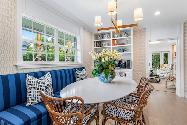 interior space with hardwood / wood-style flooring, breakfast area, and ornamental molding