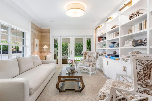 living room featuring french doors, crown molding, and wood walls