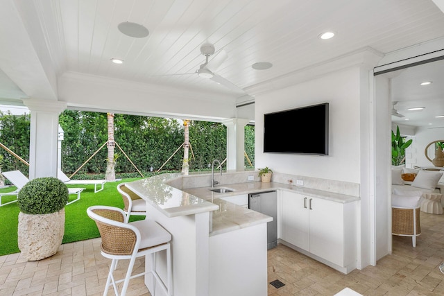 view of patio with ceiling fan, an outdoor wet bar, and exterior kitchen