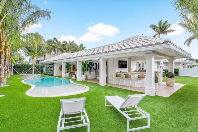 back of property featuring a patio area, a yard, and a bar