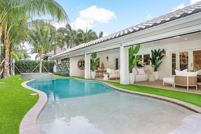 view of pool featuring an in ground hot tub, a patio, and an outdoor living space