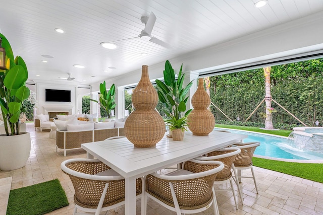 dining area with ceiling fan, ornamental molding, and an outdoor fireplace