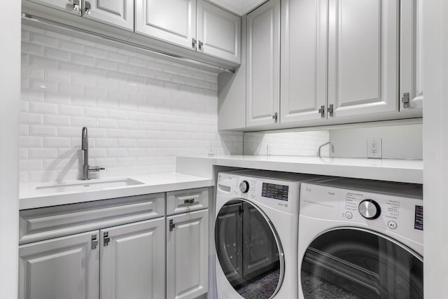 laundry area featuring cabinets, independent washer and dryer, and sink