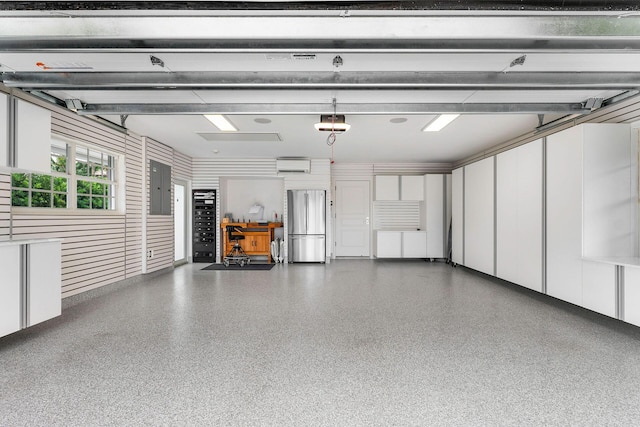 garage with a wall mounted air conditioner, stainless steel fridge, electric panel, and a garage door opener