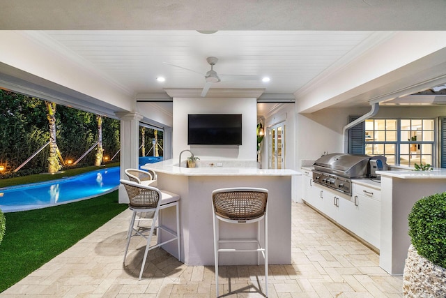 view of patio / terrace featuring area for grilling, ceiling fan, an outdoor bar, and grilling area