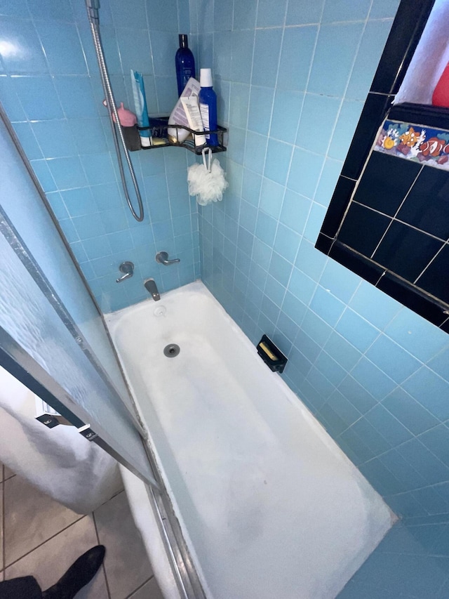 bathroom with tiled shower / bath and tile patterned flooring