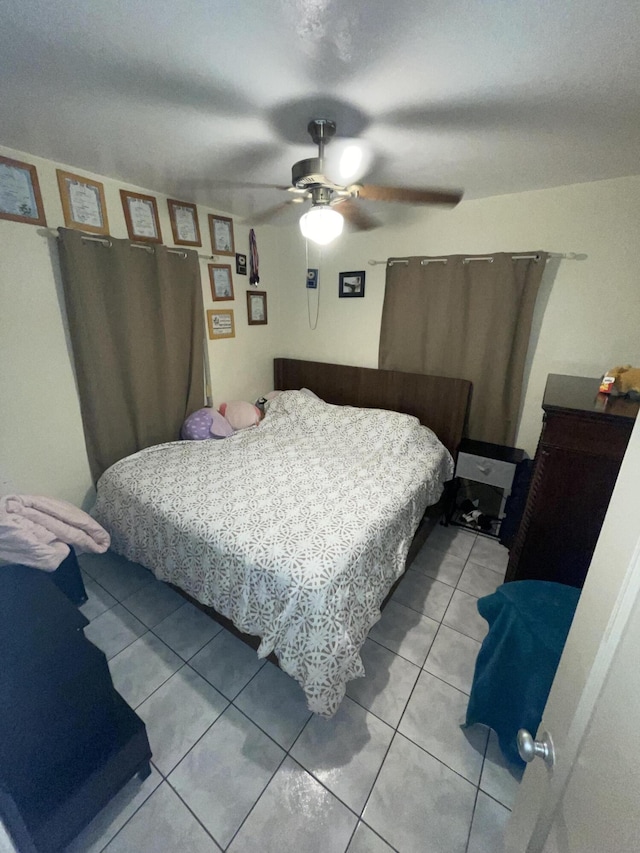 tiled bedroom featuring ceiling fan