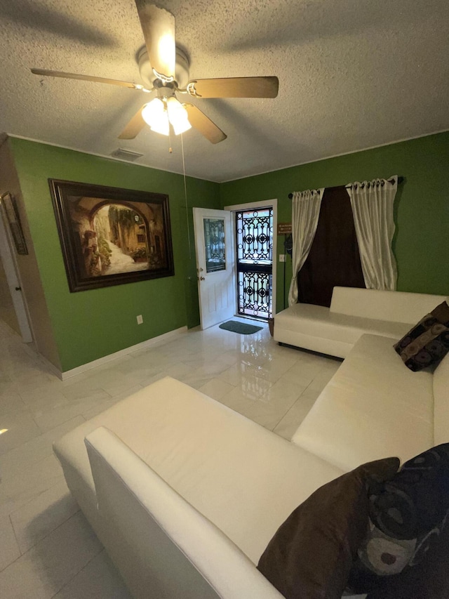 interior space with a textured ceiling and ceiling fan