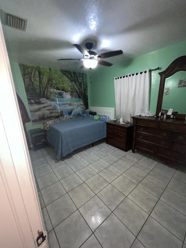 tiled bedroom featuring ceiling fan