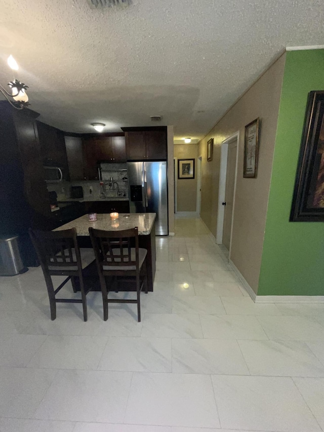 dining area featuring sink and a textured ceiling