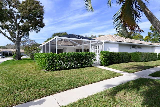 view of front of home with a lanai and a front yard