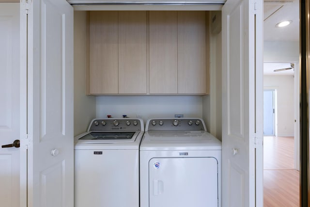 laundry room with washing machine and clothes dryer, ceiling fan, and cabinets