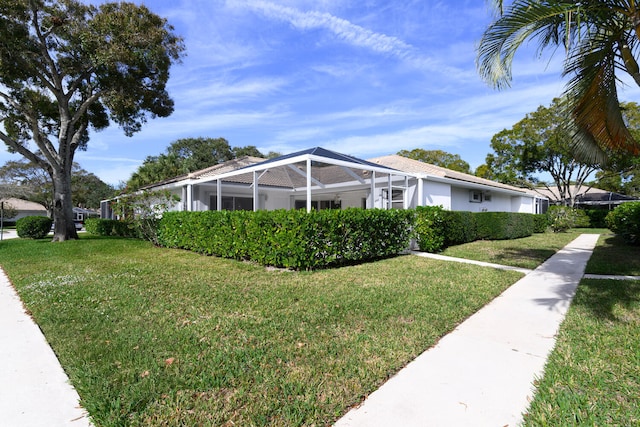 view of front facade featuring glass enclosure and a front lawn