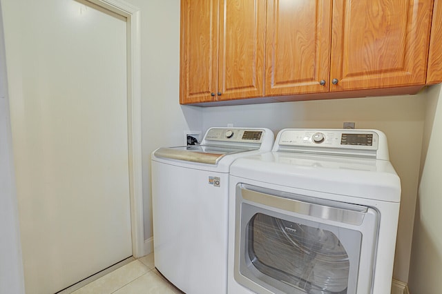 washroom featuring cabinets, separate washer and dryer, and light tile patterned flooring