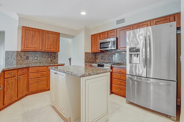 kitchen with tasteful backsplash, a kitchen island, appliances with stainless steel finishes, light tile patterned floors, and light stone counters