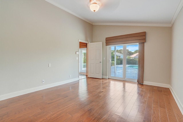 unfurnished room with hardwood / wood-style flooring, ornamental molding, and vaulted ceiling