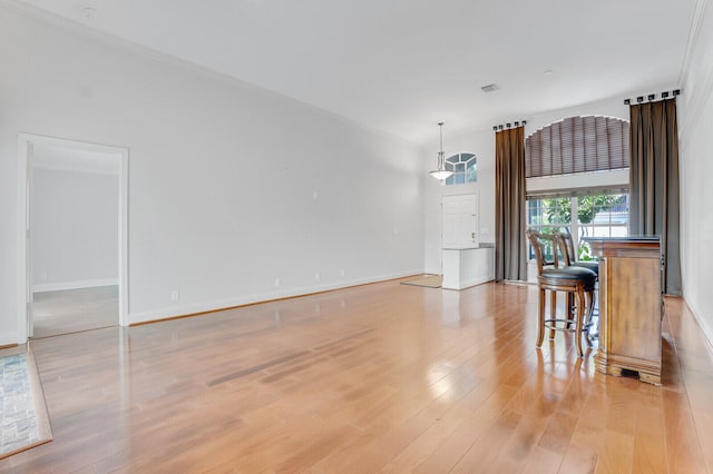 dining space with light wood-type flooring and crown molding