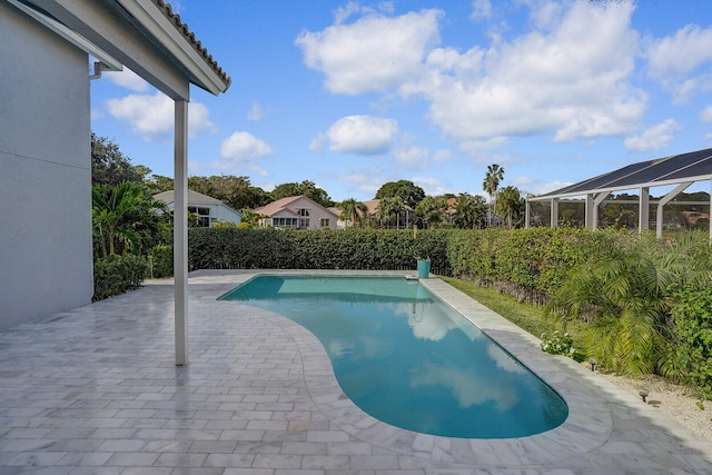 view of swimming pool with glass enclosure and a patio area