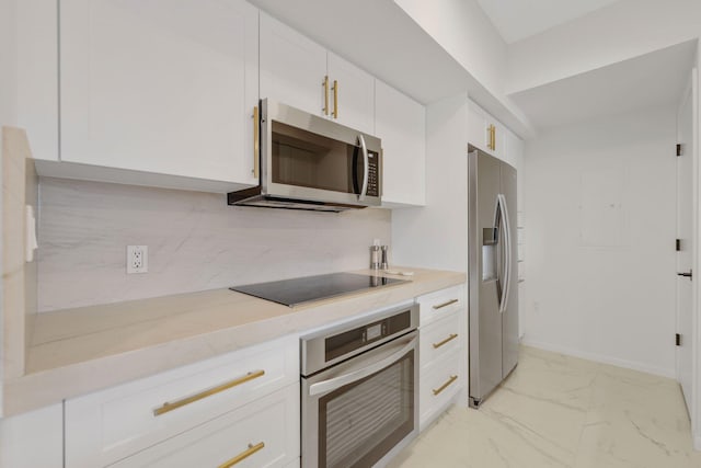 kitchen featuring decorative backsplash, stainless steel appliances, and white cabinetry