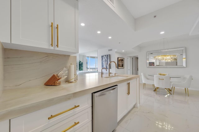 kitchen featuring white cabinets, stainless steel dishwasher, and sink