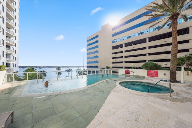 view of swimming pool with a community hot tub and a water view