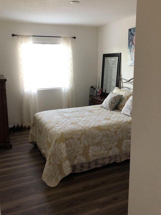 bedroom with dark wood-type flooring