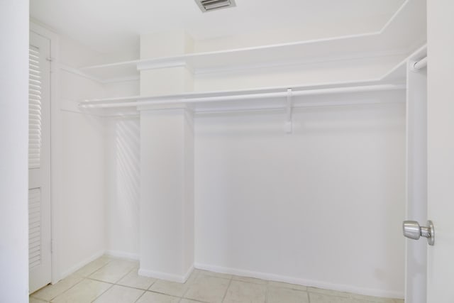 walk in closet with light tile patterned floors